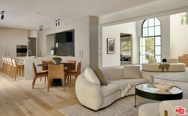 living room with sink and light wood-type flooring