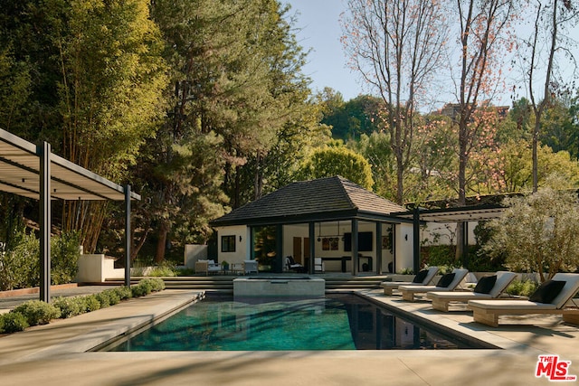 view of swimming pool with an outbuilding and a patio