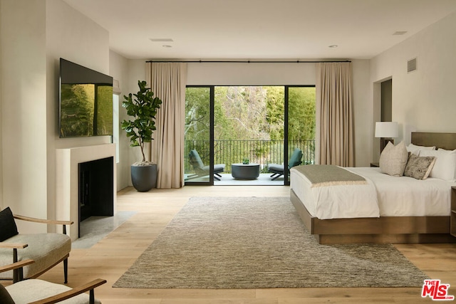 bedroom with access to exterior and light hardwood / wood-style flooring