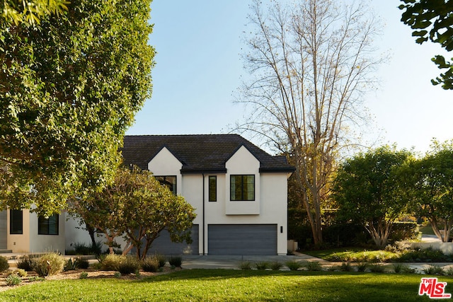 view of front of house featuring a garage and a front lawn