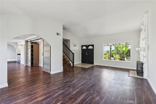 unfurnished living room featuring dark wood-type flooring and lofted ceiling