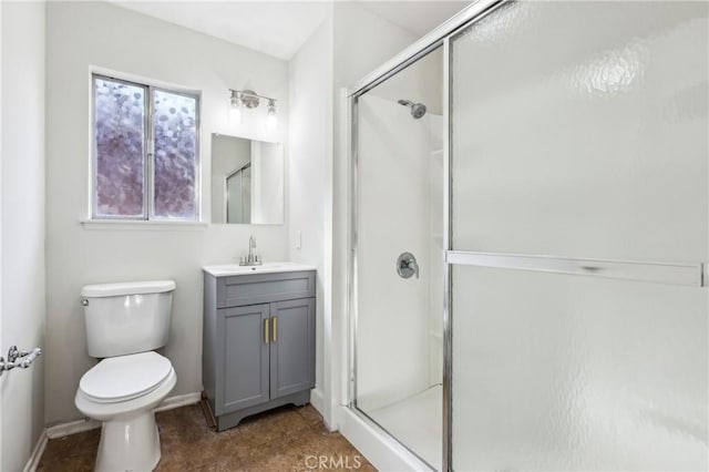 bathroom featuring toilet, a shower with door, and vanity