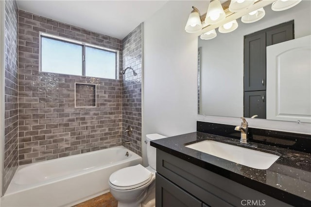 full bathroom featuring toilet, tiled shower / bath, and vanity