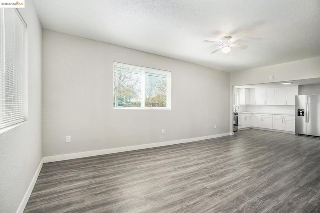 unfurnished living room with ceiling fan, wood-type flooring, and a textured ceiling