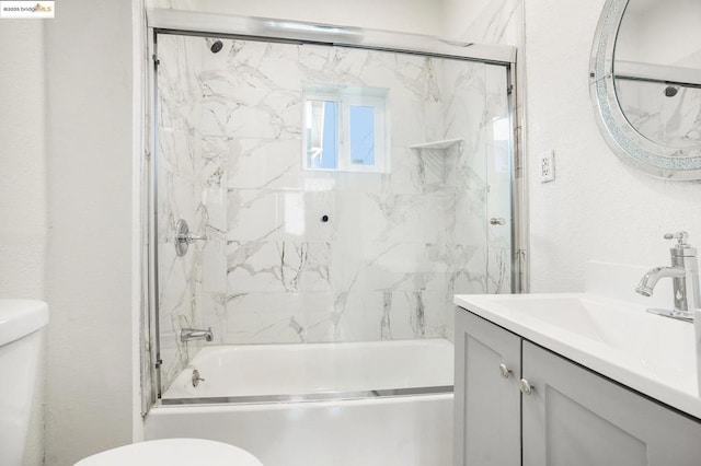 full bathroom featuring enclosed tub / shower combo, vanity, and toilet