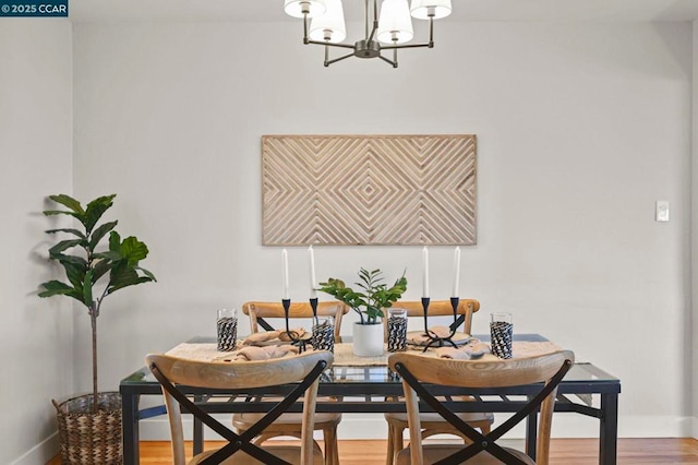 dining space featuring an inviting chandelier and hardwood / wood-style flooring