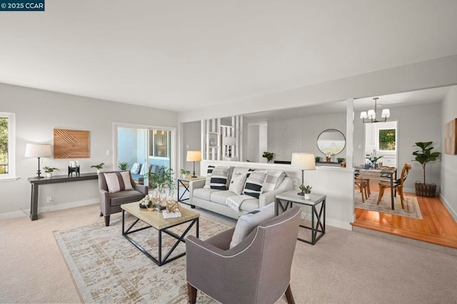 living room with light carpet and an inviting chandelier