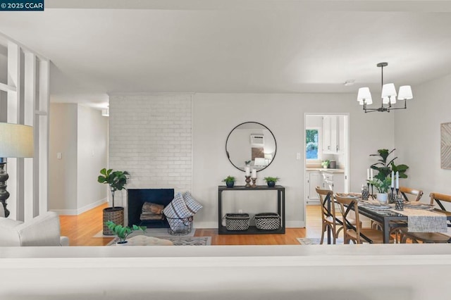 living room featuring a fireplace, hardwood / wood-style floors, and a notable chandelier