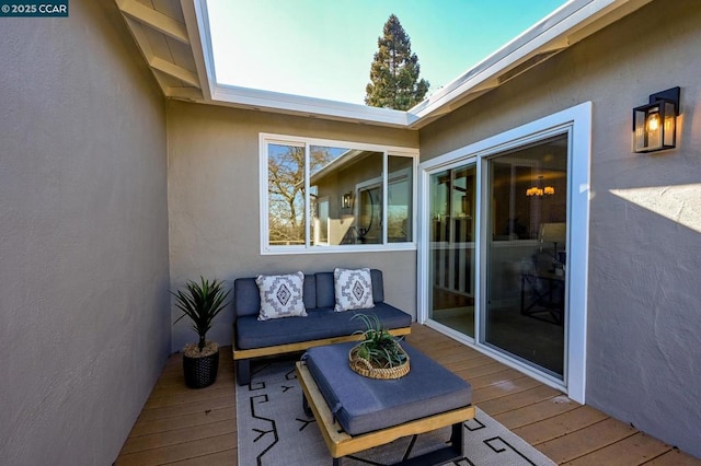 wooden terrace with an outdoor living space