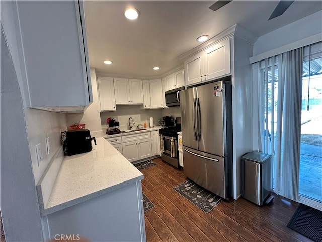 kitchen with dark wood-type flooring, white cabinetry, sink, and stainless steel appliances