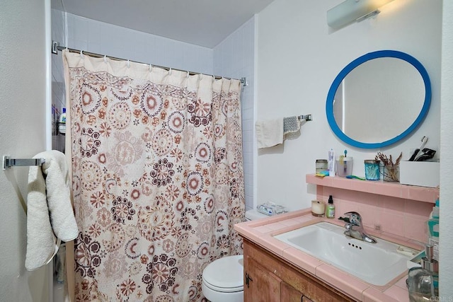 bathroom featuring vanity, toilet, and walk in shower