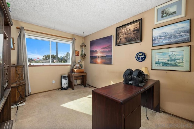 carpeted home office featuring a textured ceiling