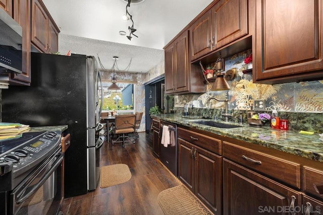 kitchen with decorative light fixtures, stainless steel appliances, sink, stone countertops, and dark hardwood / wood-style floors