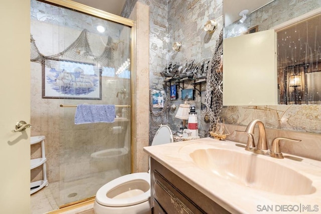 bathroom featuring toilet, tile walls, an enclosed shower, and vanity