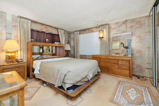 bedroom with light carpet and a textured ceiling