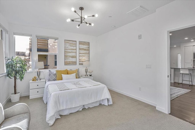 bedroom with light carpet and an inviting chandelier