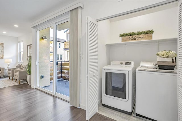 washroom with hardwood / wood-style flooring and washer and dryer