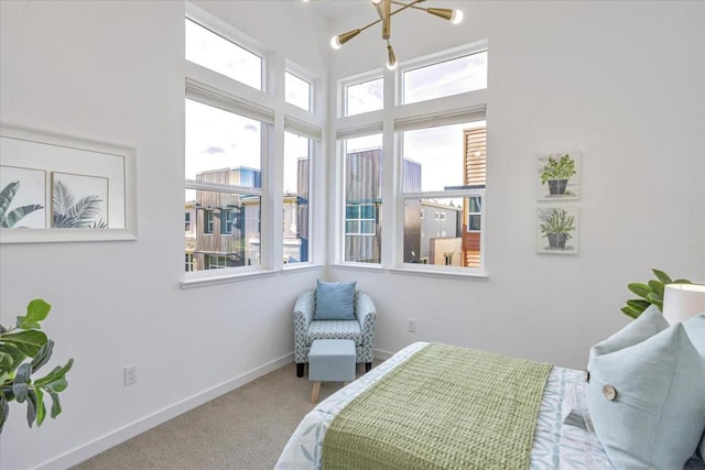 bedroom with multiple windows, light carpet, and a notable chandelier