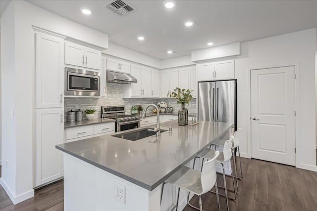 kitchen featuring white cabinetry, appliances with stainless steel finishes, and an island with sink