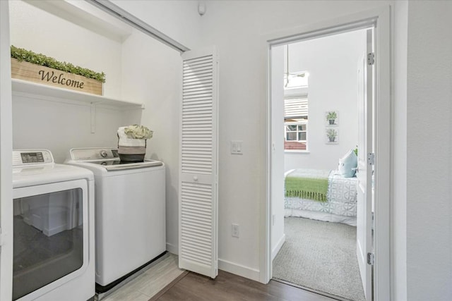 laundry area featuring wood-type flooring and independent washer and dryer