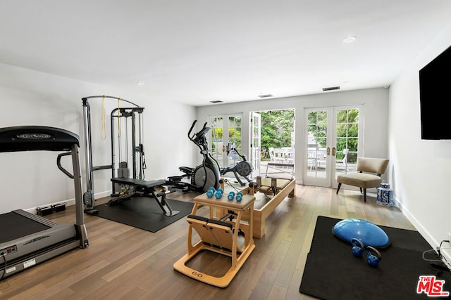 exercise area with light hardwood / wood-style flooring and french doors