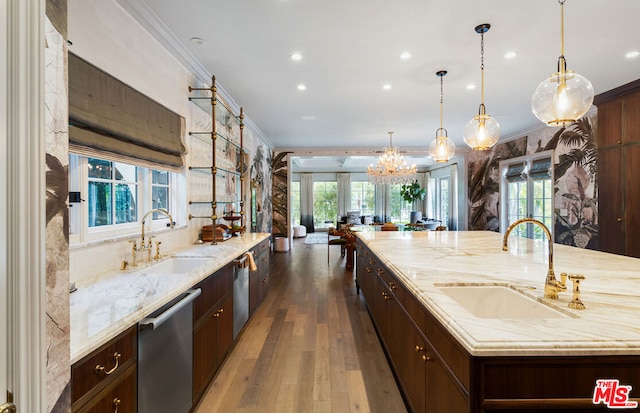 kitchen with a wealth of natural light, a spacious island, stainless steel dishwasher, sink, and pendant lighting