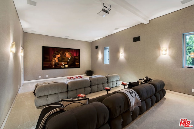 home theater room featuring light colored carpet and beamed ceiling