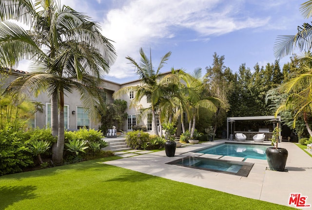 view of swimming pool with an in ground hot tub, a lawn, and a patio