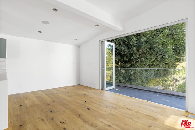 unfurnished room with hardwood / wood-style floors and lofted ceiling with beams