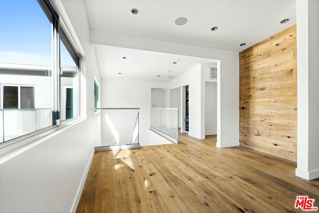 empty room with wood-type flooring and wood walls