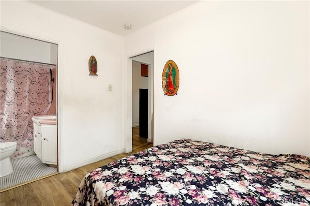 bedroom featuring ensuite bathroom and light hardwood / wood-style floors