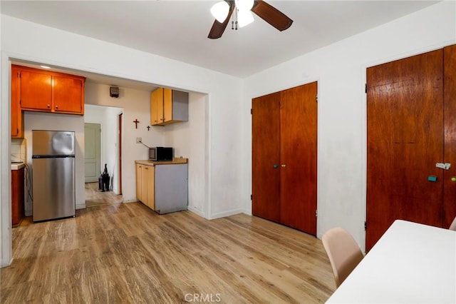 kitchen with light hardwood / wood-style floors, ceiling fan, and appliances with stainless steel finishes