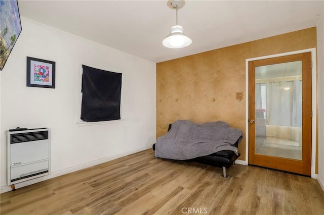 living area with heating unit and light hardwood / wood-style flooring