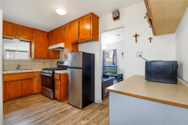 kitchen featuring light hardwood / wood-style floors, sink, backsplash, and stainless steel appliances