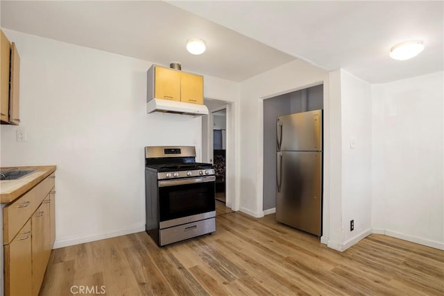 kitchen with light wood-type flooring, light brown cabinetry, and appliances with stainless steel finishes