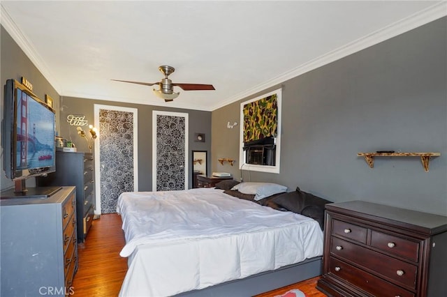 bedroom featuring ceiling fan, dark wood-type flooring, and ornamental molding