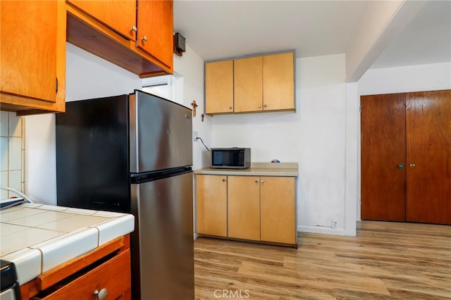 kitchen with stainless steel appliances and light hardwood / wood-style floors