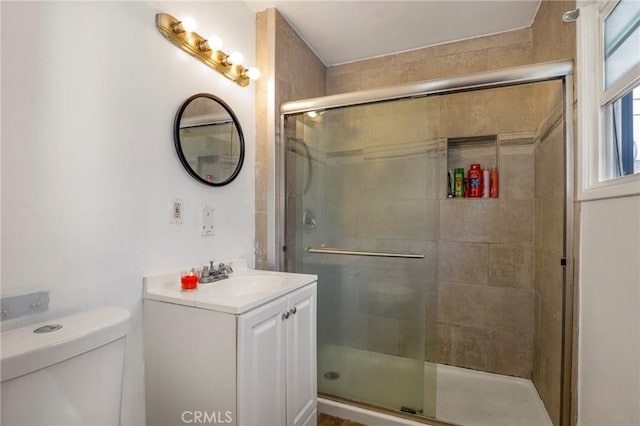 bathroom with toilet, a shower with door, and vanity