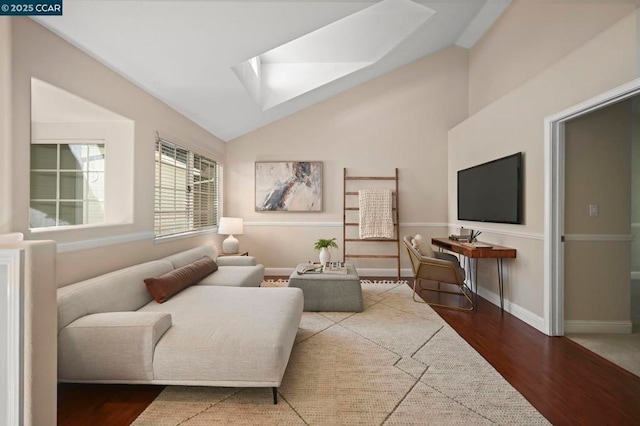 living room with hardwood / wood-style floors and lofted ceiling with skylight