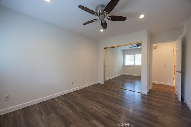 unfurnished bedroom with dark wood-type flooring, ceiling fan, and a closet