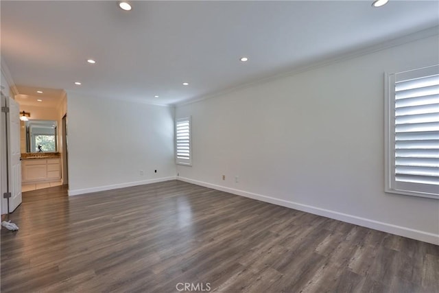 spare room with ornamental molding and dark hardwood / wood-style floors