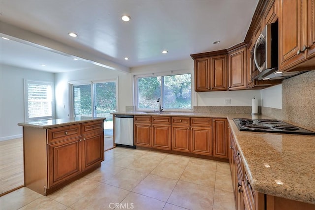 kitchen featuring sink, plenty of natural light, stainless steel appliances, and a kitchen island