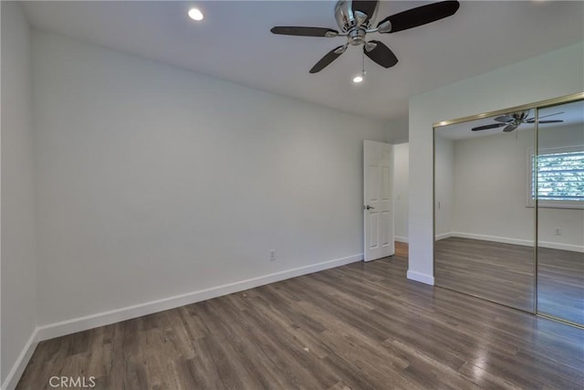 unfurnished bedroom featuring ceiling fan, dark hardwood / wood-style flooring, and a closet