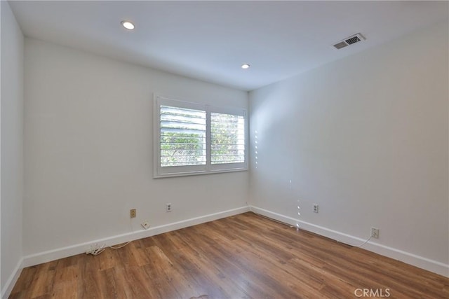 unfurnished room with wood-type flooring