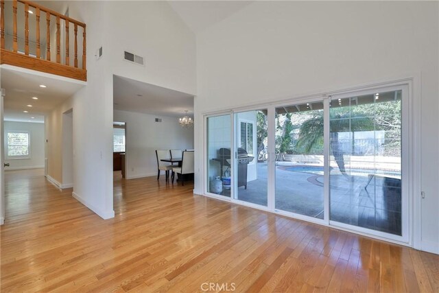 3179 Canal Point Dr, Hacienda Heights, CA 91745 - unfurnished room with light wood-style flooring, a high ceiling, plenty of natural light, a chandelier, and baseboards