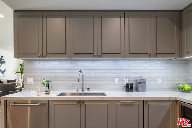 kitchen featuring dishwasher, sink, tasteful backsplash, gray cabinetry, and beverage cooler