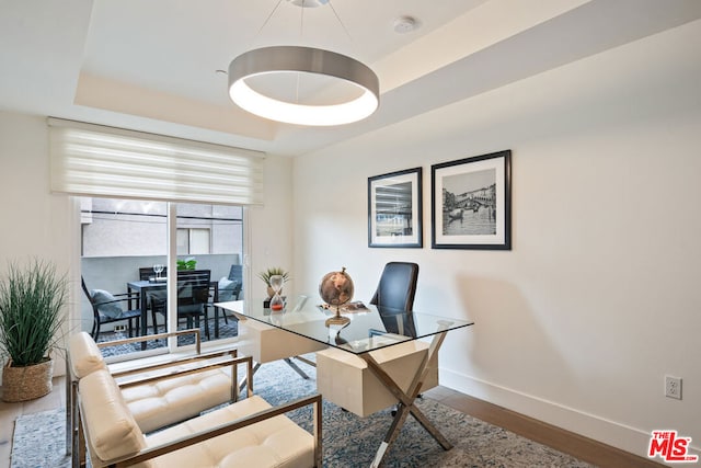 office space featuring hardwood / wood-style floors and a raised ceiling