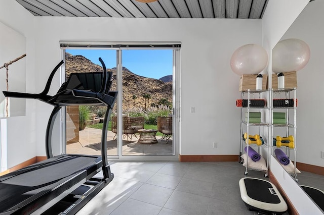 exercise area with a mountain view and light tile patterned floors