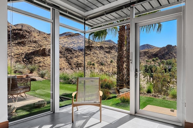 doorway to outside with a mountain view, a wealth of natural light, light tile patterned floors, and floor to ceiling windows