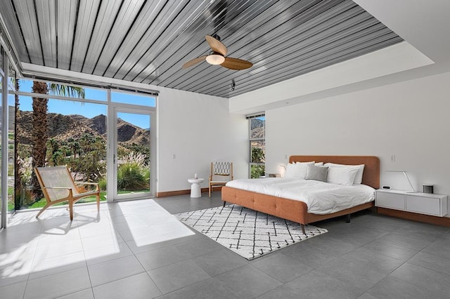 bedroom featuring a mountain view, ceiling fan, and access to outside